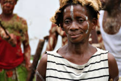 Kvinne fra Kasai-Occidental i Kongo med ansiktsmaling og pelslue
